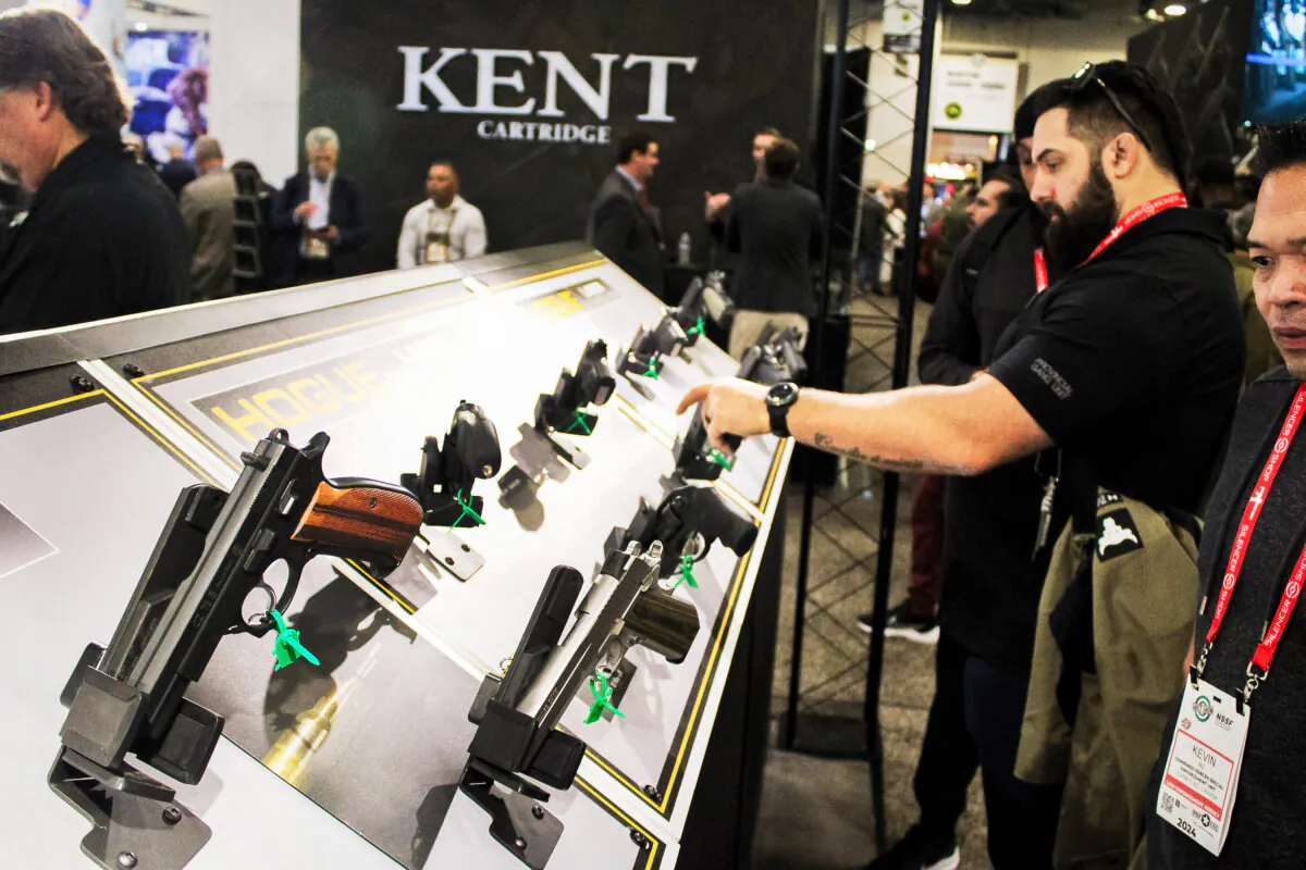 Attendees look at pistols on display at the National Shooting Sports Foundation's annual Shooting, Hunting, and Outdoor Trade (SHOT) Show in Las Vegas on Jan. 23, 2024. (Michael Clements/The Epoch Times)