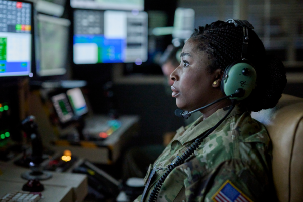 woman at console with headset in LAND OF BAD