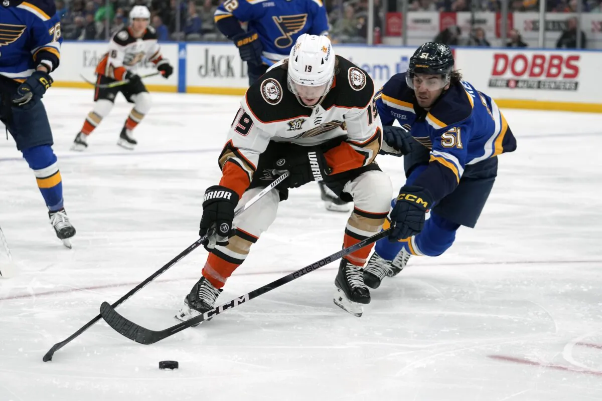 Anaheim Ducks' Troy Terry (19) and St. Louis Blues' Matthew Kessel (51) battle for a loose puck during the third period of an NHL hockey game in St. Louis on March 17, 2024. (Jeff Roberson/AP Photo)