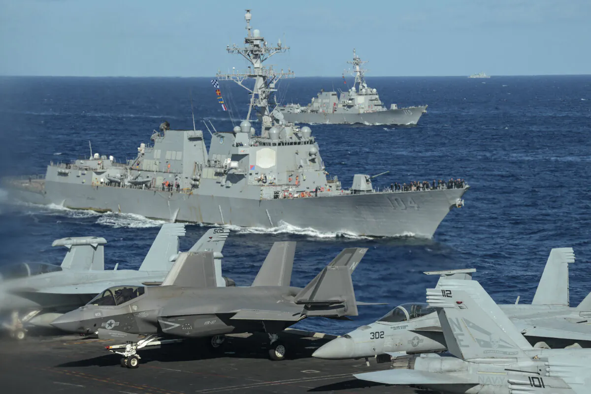 A Chinese military vessel (back R)—some 5 miles away—observing as the Arleigh-Burke class guided missile destroyers USS Sterett (front) and the USS Rafael Peralta (behind) are seen from the deck of the USS Carl Vinson aircraft carrier as they join a three-day maritime exercise between the United States and Japan in the Philippine Sea on Jan. 31, 2024. (Richard a. Brooks/AFP via Getty Images)