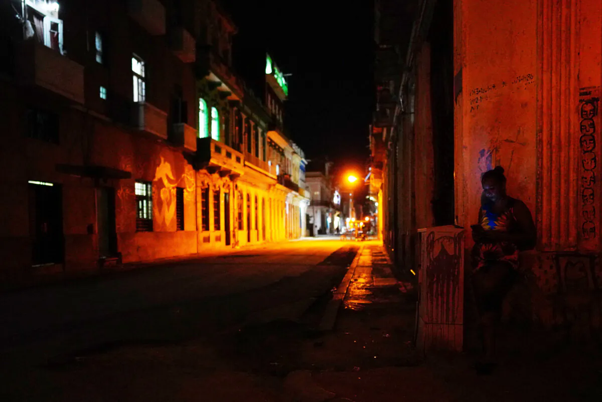 A woman uses her mobile phone in downtown Havana on March 17, 2024. (Alexandre Meneghini/Reuters)