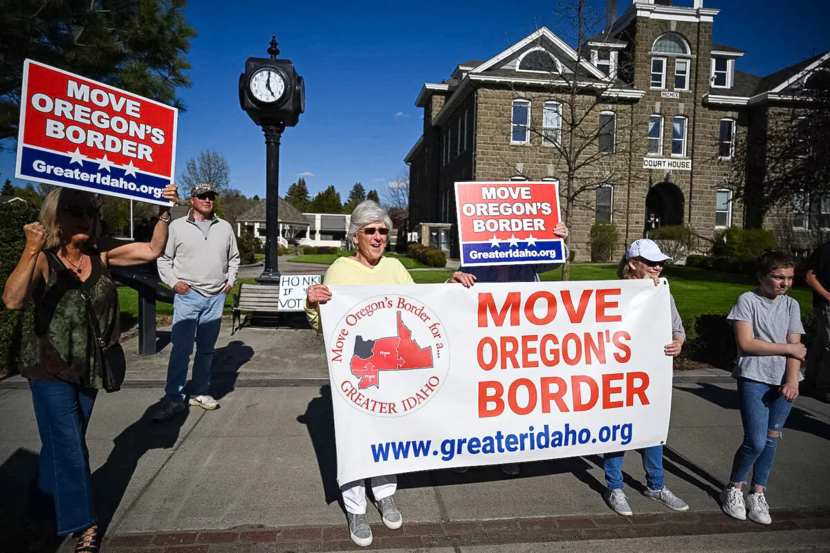 People hold signs in favor of the Greater Idaho Movement in Enterprise, Oregon, on May 12, 2023. (Robyn Beck/AFP via Getty Images)