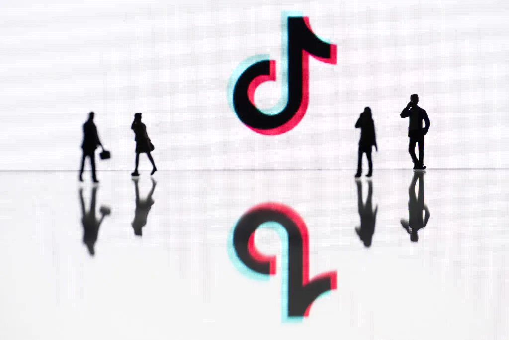 This photograph taken in Mulhouse, eastern France on Oct. 19, 2023, shows figurines next to the logo of the social media video sharing app Tik Tok reflected in mirrors. (Sebastien Bozon/AFP via Getty Images)