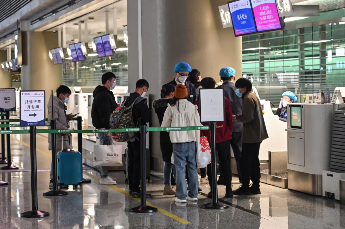 People stand at the check-in counters of China Eastern Airlines in Hongqiao International Airport in Shanghai on March 21, 2022.(Hector Retamal/AFP via Getty Images)
