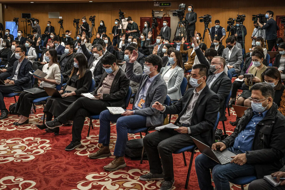 Journalists raise their hands to ask questions at a press conference in Beijing on March 7, 2022. (Andrea Verdelli/Getty Images)