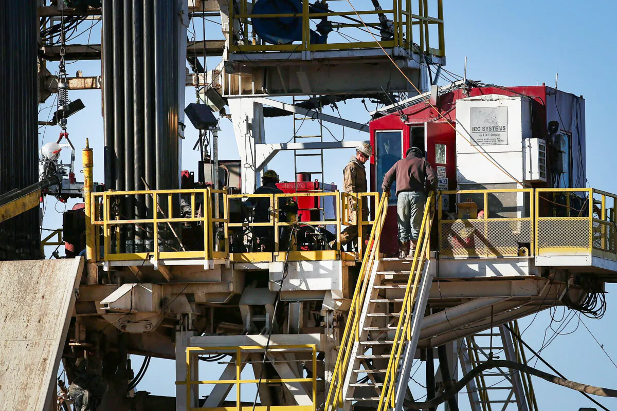 Workers stand on the platform of a fracking rig in the Permian Basin oil field in Midland, Texas on Jan. 21, 2016. (Spencer Platt/Getty Images)