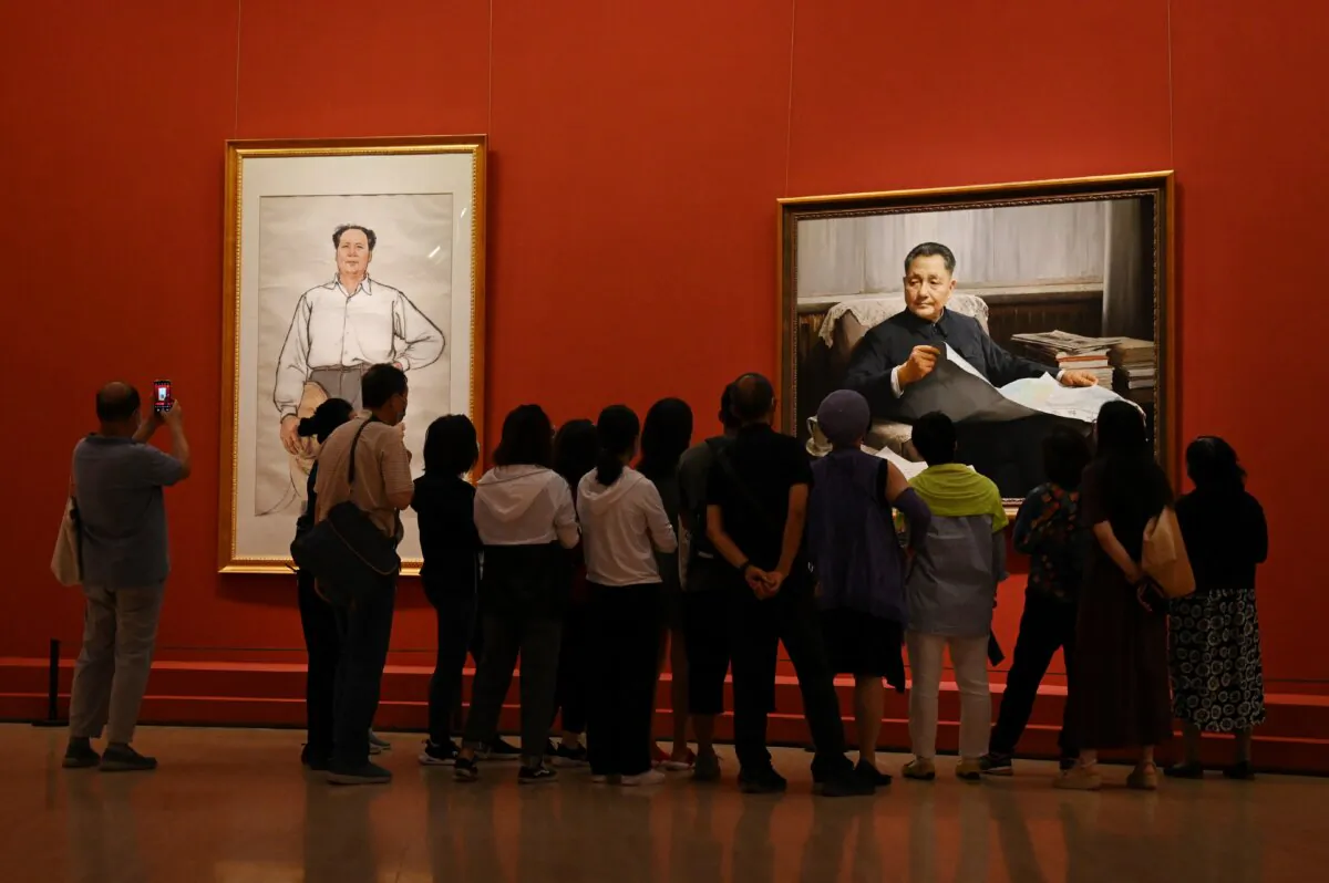 Visitors look at paintings of late communist leaders Mao Zedong (L) and Deng Xiaoping at an art exhibition celebrating the 100th anniversary of the founding of the Communist Party in Beijing on June 24, 2021. (Greg Baker/AFP via Getty Images)