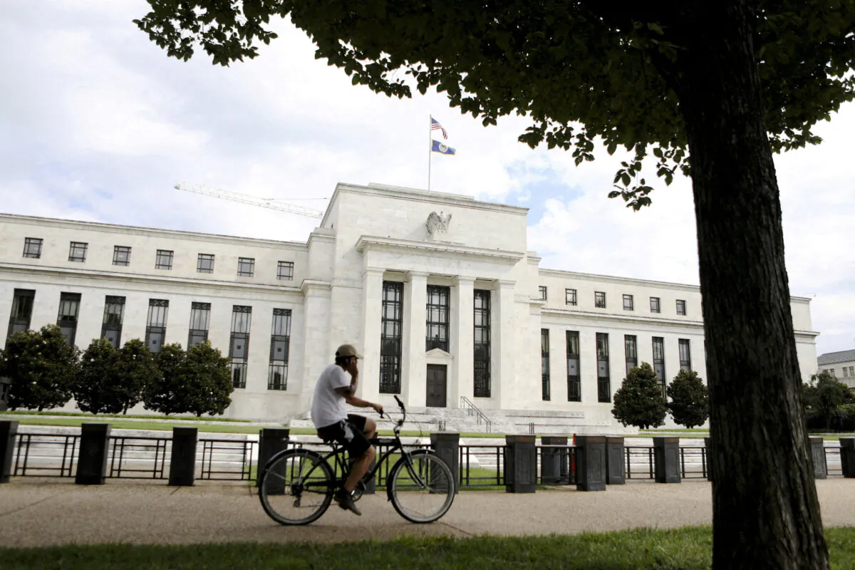 FILE PHOTO: A cyclist passes the Federal Reserve building in Washington, DC, U.S., August 22, 2018. REUTERS/Chris Wattie/File Photo