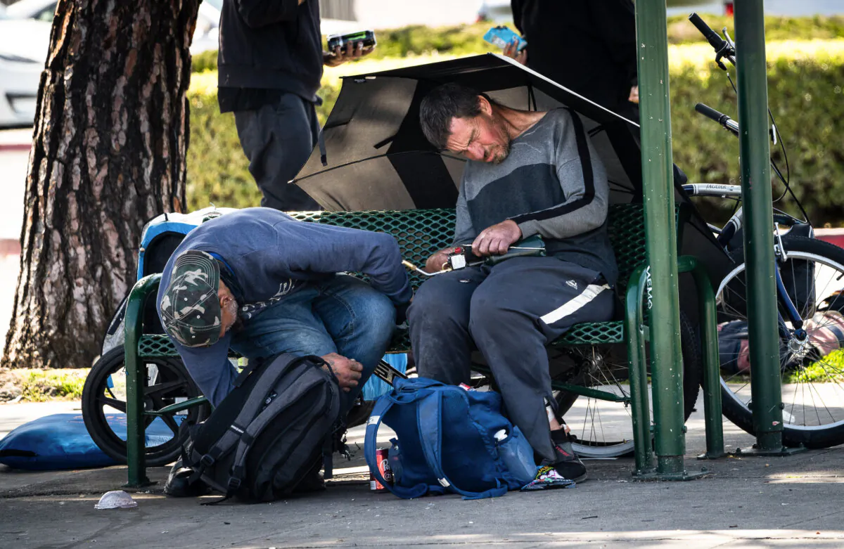 A homeless man holds a blowtorch he used to heat fentanyl in Garden Grove, Calif., on April 3, 2023. (John Fredricks/The Epoch Times)
