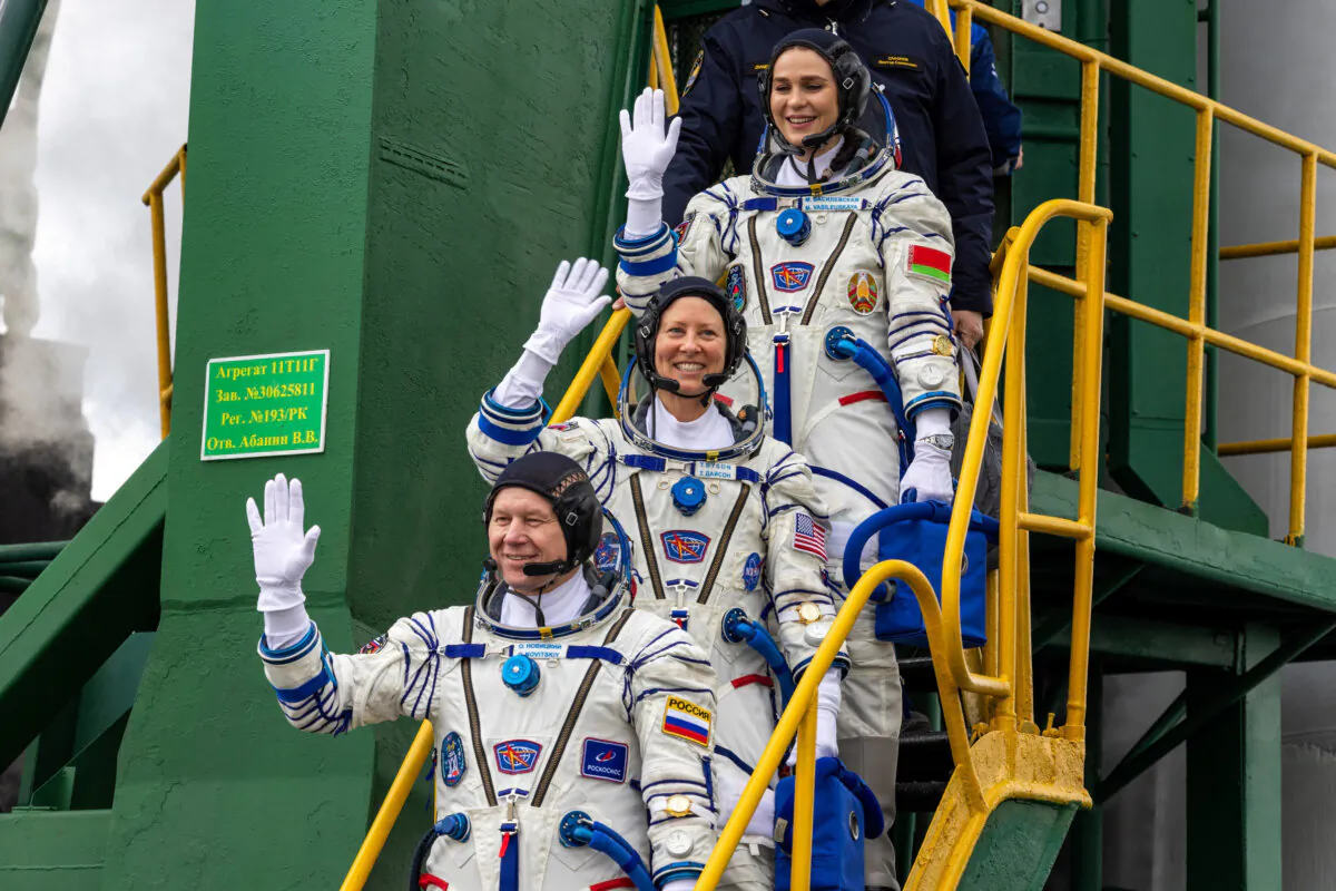 NASA astronaut Tracy Dyson, (C), Oleg Novitsky of Roscosmos, (bottom), and Marina Vasilevskaya of Belarus wave as they board to the space ship at the Russian leased Baikonur cosmodrome, Kazakhstan, on March 21, 2024. (Roscosmos space corporation via AP)