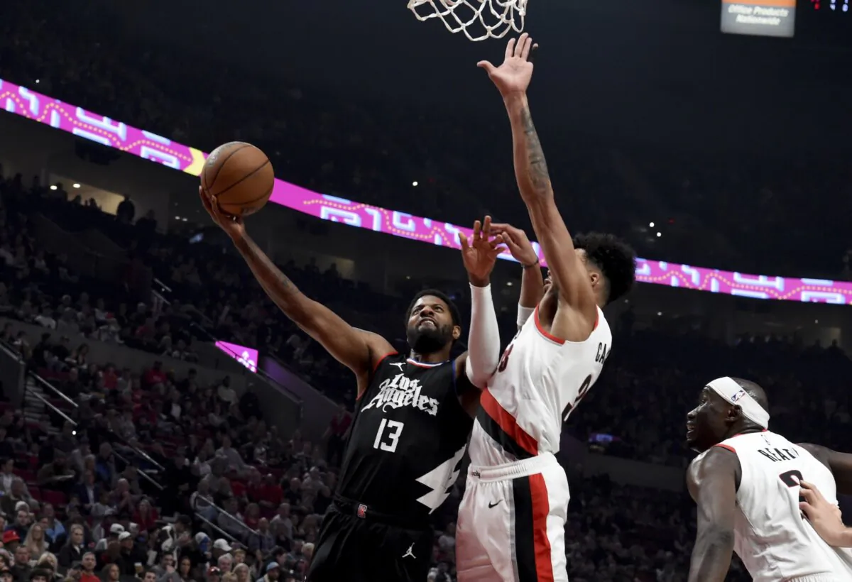 Los Angeles Clippers forward Paul George (L) drives to the basket against Portland Trail Blazers forward Toumani Camara (C) as center Duop Reath (R) closes in during the first half of an NBA basketball game in Portland on March 22, 2024. (Steve Dykes/AP Photo)