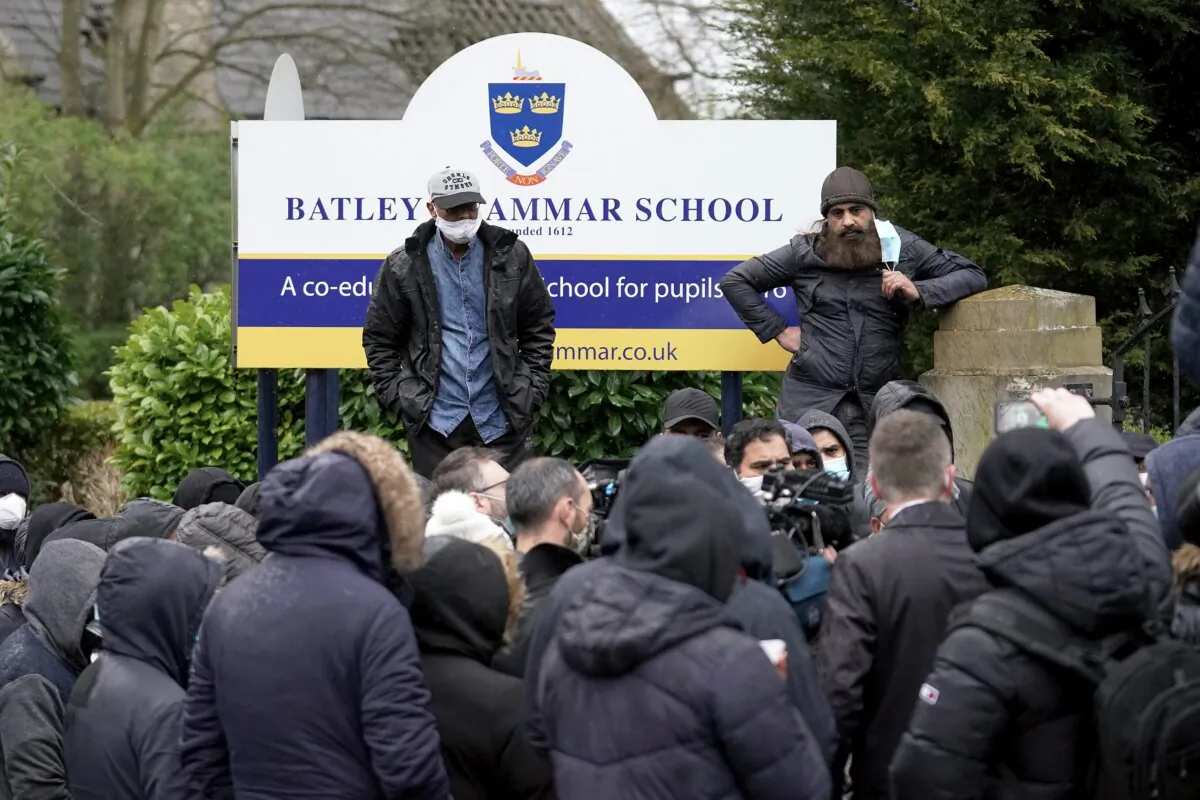 People gather outside the gates of Batley Grammar School, after a teacher was suspended for showing an image of the Prophet Muhammad in class, in Batley, England, on March 26, 2021. (Christopher Furlong/Getty Images)