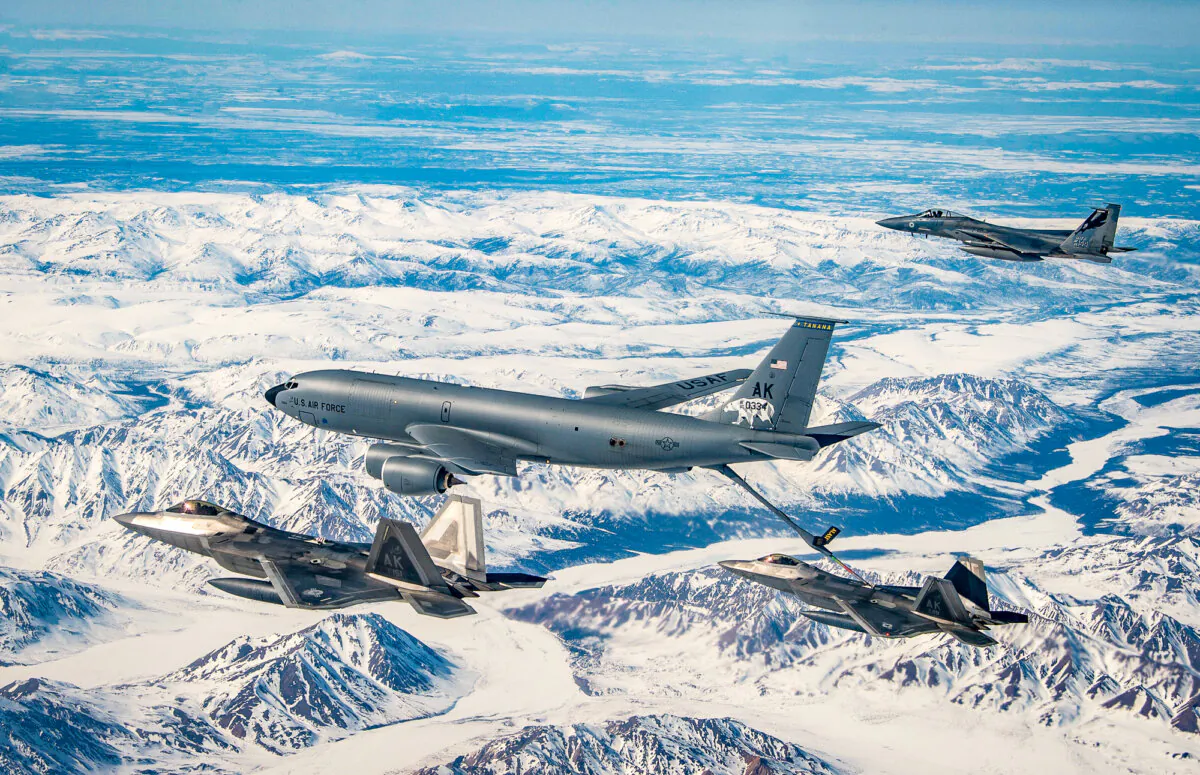 A KC-135 Stratotanker from the 168th Air Refueling Wing refuels F-22 Raptors from the 3rd Wing over the Joint Pacific Alaska Range Complex flying along side with an F-15 Eagles from the 144th Fighter Wing, on April 18, 2022. (Air National Guard photo by Master Sgt. Charles Vaughn)