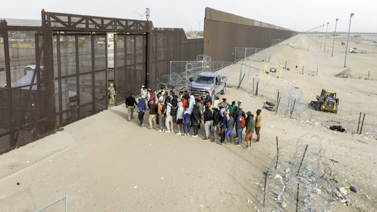In an aerial view, immigrants wait for transport and processing after crossing the U.S.–Mexico border in El Paso, Texas, on March 13, 2024. (John Moore/Getty Images)