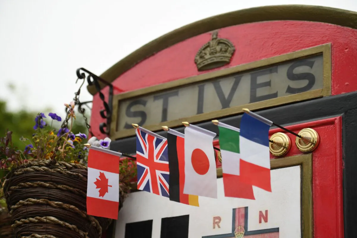 The Canadian flag is seen with flags of other G7 nations on a repurposed red telephone box ahead of the G7 summit in Cornwall, UK, on June 10, 2021. (Oli Scarff/AFP via Getty Images)