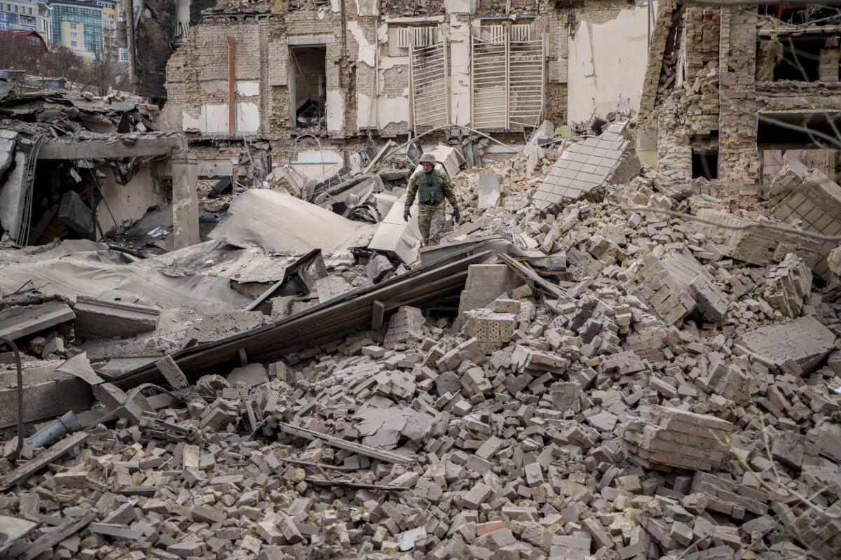 A Ukrainian serviceman inspects the damage to a building at the Pecherskyi district, after a Russian air attack in Kyiv, Ukraine, on March 25, 2024. (Vadim Ghirda/The Canadian Press/AP)
