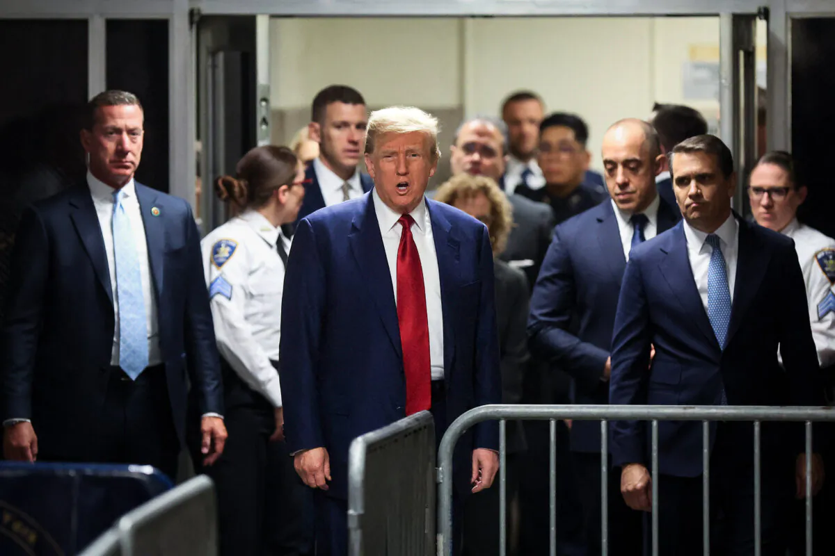 Former President Donald Trump speaks briefly to reporters in a hallway outside the courtroom as he arrives for his hearing to determine the date of his trial for allegedly covering up hush money payments linked to extramarital affairs, at Manhattan Criminal Court in New York City on March 25, 2024. (Brendan McDermid/Pool/AFP via Getty Images)