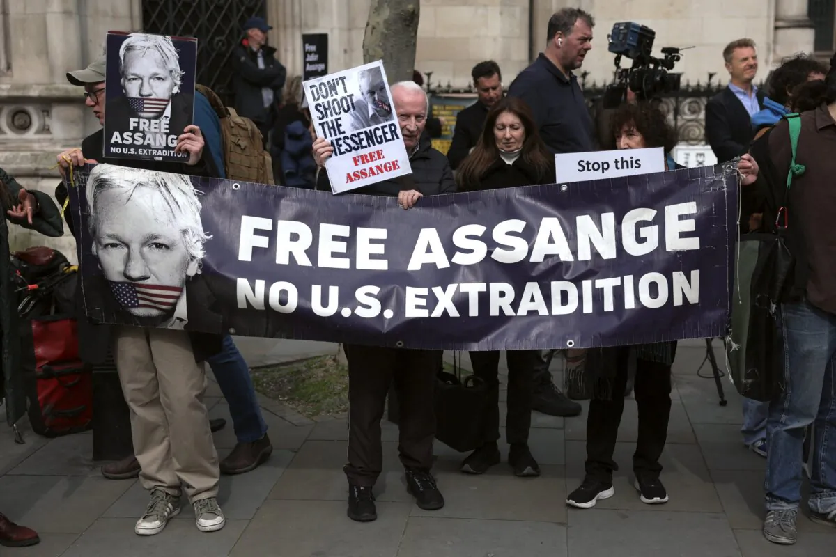 Supporters of WikiLeaks founder Julian Assange hold a banner and placards outside the Royal Courts of Justice, Britain's High Court, in central London on March 26, 2024. (Daniel Leal/AFP via Getty Images)