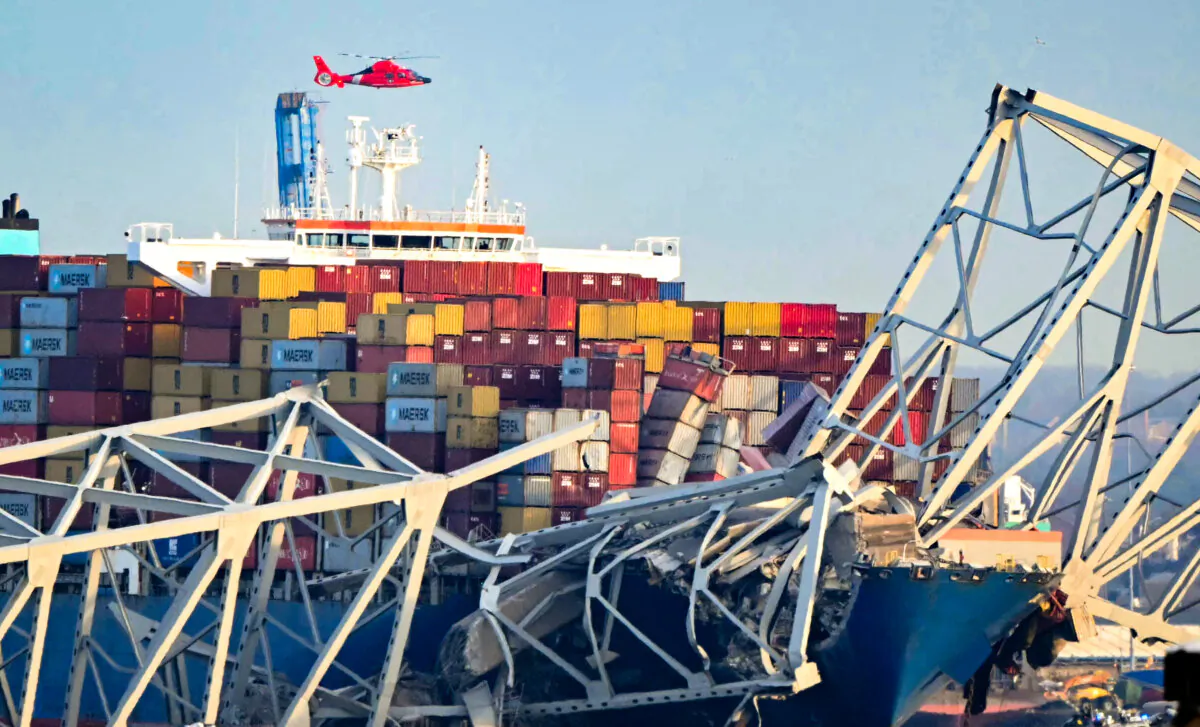 The steel frame of the Francis Scott Key Bridge sit on top of a container ship after the bridge collapsed collapsed in Baltimore, Maryland, on March 26, 2024. The bridge collapsed after being struck by a container ship, sending multiple vehicles and up to 20 people plunging into the harbor below. (Mandel Ngan/AFP via Getty Images)