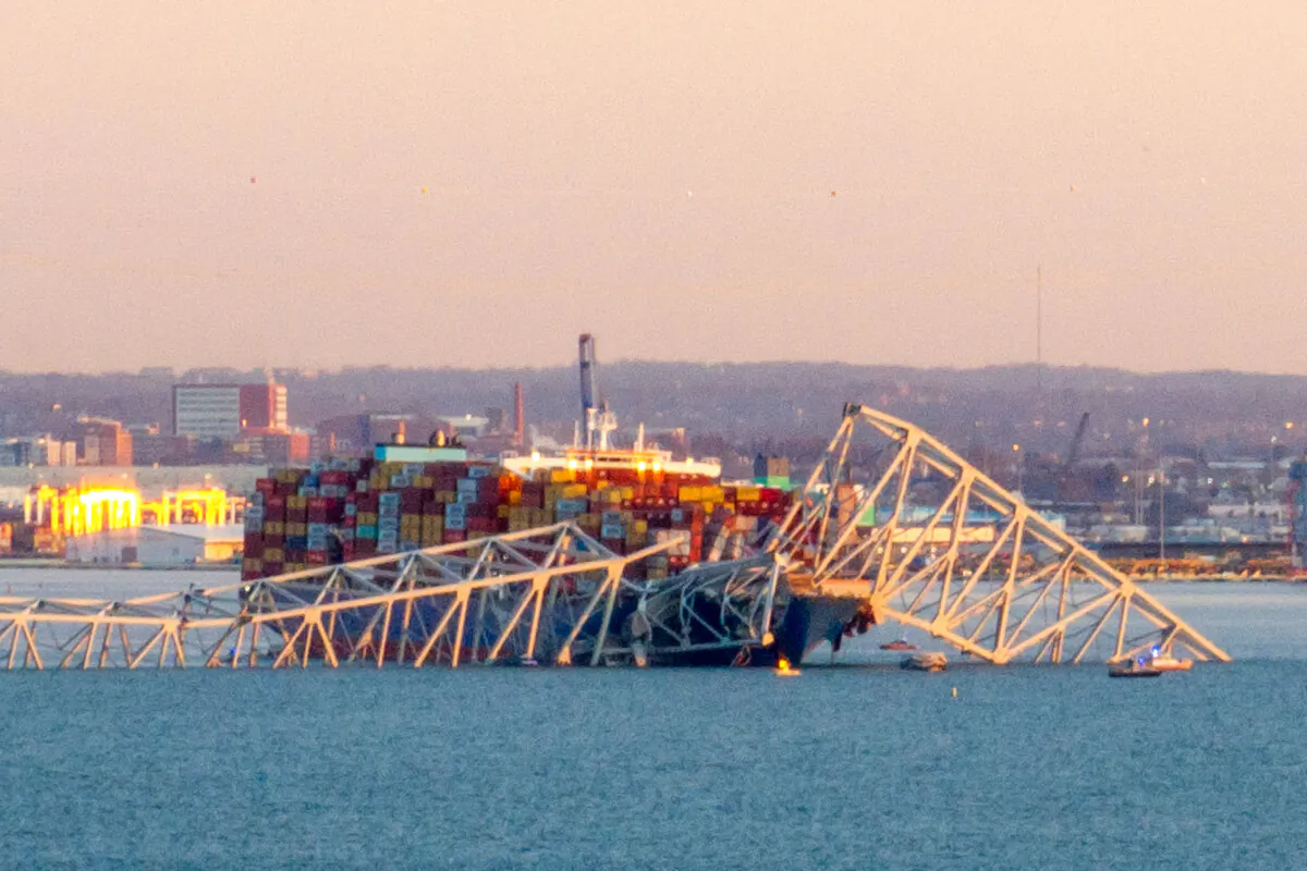 The steel frame of the Francis Scott Key Bridge sit on top of a container ship after the bridge collapsed collapsed in Baltimore, Maryland, on March 26, 2024. (Mandel Ngan/AFP via Getty Images)