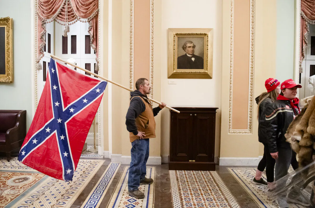 Kevin Seefried holds a Confederate flag outside the Senate Chamber during a protest after breaching the U.S. Capitol in Washington, on Jan. 6, 2021. (Saul Loeb/AFP/Getty Images)