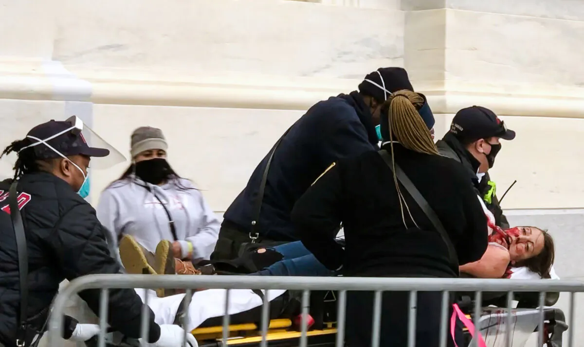 Paramedics rush a mortally wounded Ashli Babbitt to the rescue squad just after 3 p.m. on Jan. 6, 2021. (Steve Baker/Special to The Epoch Times)