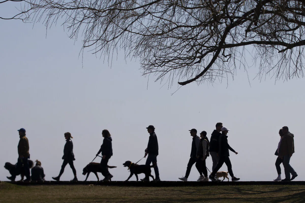 People walk along the boardwalk in Toronto's east end on April 4, 2021. (The Canadian Press/Chris Young)