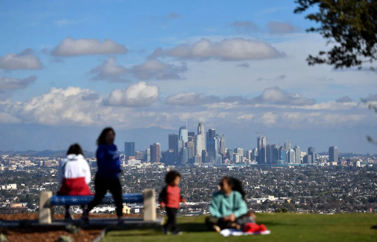 People enjoy the sunny afternoon on New Year's Eve in a Los Angeles park with a view of the downtown skyline on Dec. 31, 2021. (Chris Delmas/AFP via Getty Images)