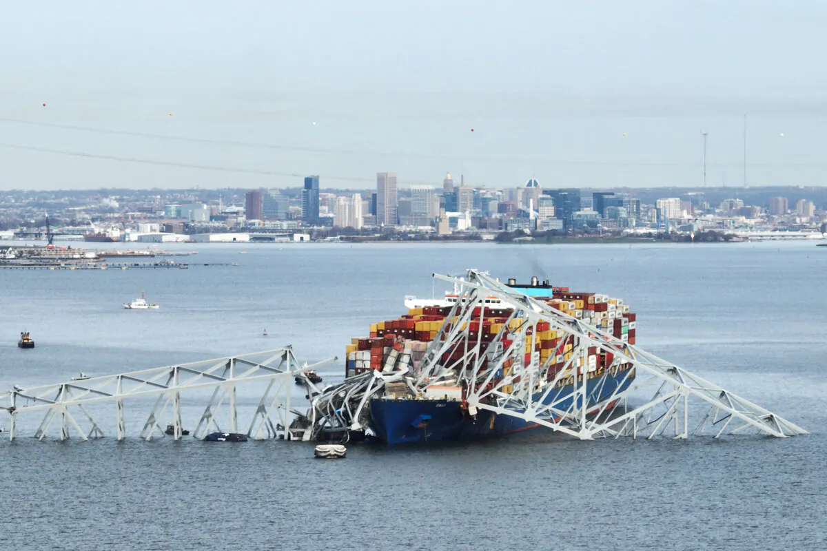 The steel frame of the Francis Scott Key Bridge sits on top of a container ship after the bridge collapsed in Baltimore, Md., on March 26, 2024. (Jim Watson/AFP via Getty Images)