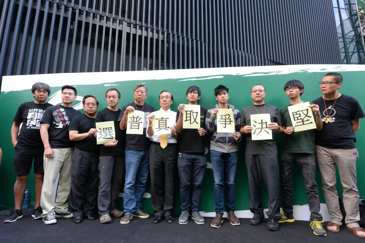 In 2014, after Hong Kong people's bid for "double universal suffrage" failed, the "Let Love and Peace Occupy Central" movement broke out. On Oct. 9, after the Hong Kong government unilaterally terminated the dialogue, activists announced the launch of a new round of non-cooperation actions and continued to occupy the streets to pressure the authorities to fulfill their demand for universal suffrage. Most of the people in the photo, including Joshua Wong (R2) and Benny Tai (R3), are still in prison. (Sung Pi-Lung/The Epoch Times)