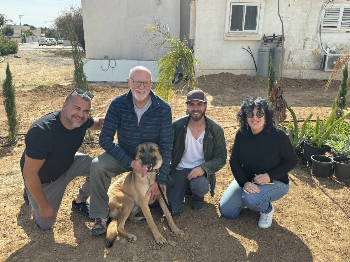 Shalom Peretz (L) with Roni Gilo (2nd L), Eden Kogan (2nd R), (R) Michal Gilo, and Peretz's dog Sky, whom the Gilos cared for following Mr. Kogan's rescue of the German shepherd. The dog was reunited with the Peretz family on March 9, 2024, in Shokeda, Israel. (Dan M. Berger/The Epoch Times.)