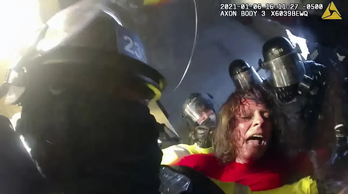 Victoria White is jostled and spun around by police in the Lower West Terrace tunnel at the U.S. Capitol on Jan. 6, 2021. (Metropolitan Police Department/Screenshot via The Epoch Times)
