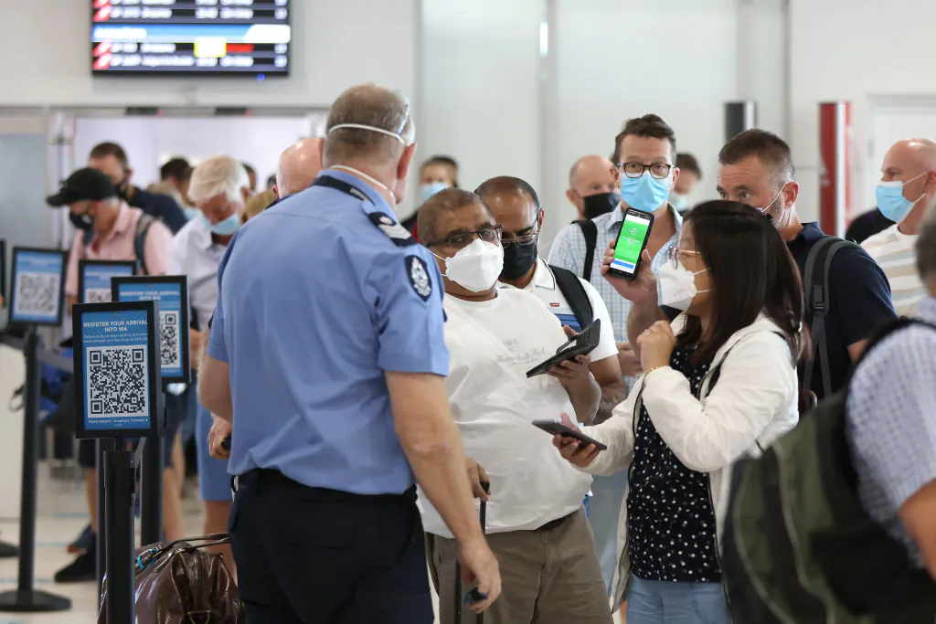 Arriving passengers talk with a WA Police Officer at the Perth Domestic Airport on March 3, 2022 in Perth, Australia. (Paul Kane/Getty Images)