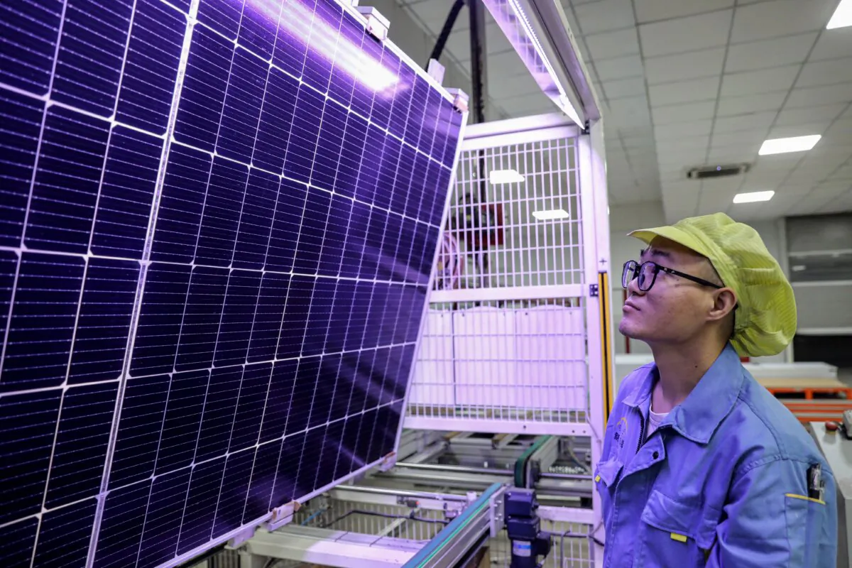A worker producing solar photovoltaic modules used for solar panels at a workshop in Huaian, Jiangsu Province, China, on Sept. 25, 2023. (STR/AFP via Getty Images)