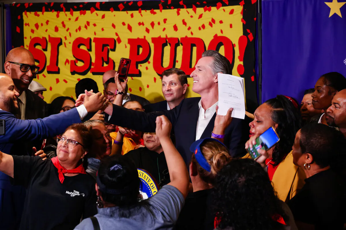 California Gov. Gavin Newsom signs the fast food bill surrounded by fast food workers at the SEIU Local 721 in Los Angeles on Sept. 28, 2023. (Courtesy of Office of Governor Gavin Newsom)