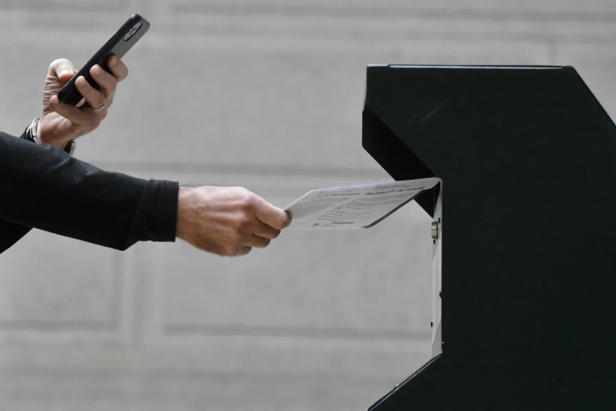 A man photographs himself sending a piece of mail in a file photo. (Mark Makela/Getty Images)