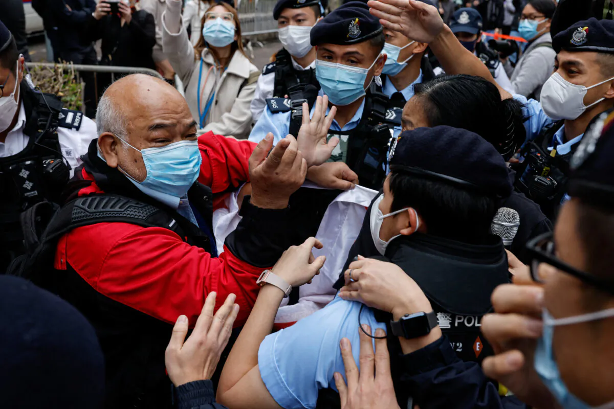 A supporter scuffles with police the West Kowloon Magistrates' Courts building during the hearing of the 47 pro-democracy activists charged with conspiracy to commit subversion under the national security law, in Hong Kong on Feb. 6, 2023. (Tyrone Siu/Reuters)