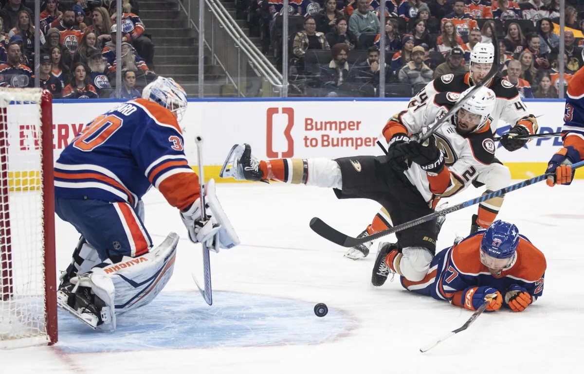 Anaheim Ducks' Benoit-Olivier Groulx (24) and Edmonton Oilers' Brett Kulak (27) battle in front as Oilers goalie Calvin Pickard (30) makes the save during the first period of an NHL hockey game in Edmonton, Alberta on March 30, 2024. (Jason Franson/The Canadian Press via AP)
