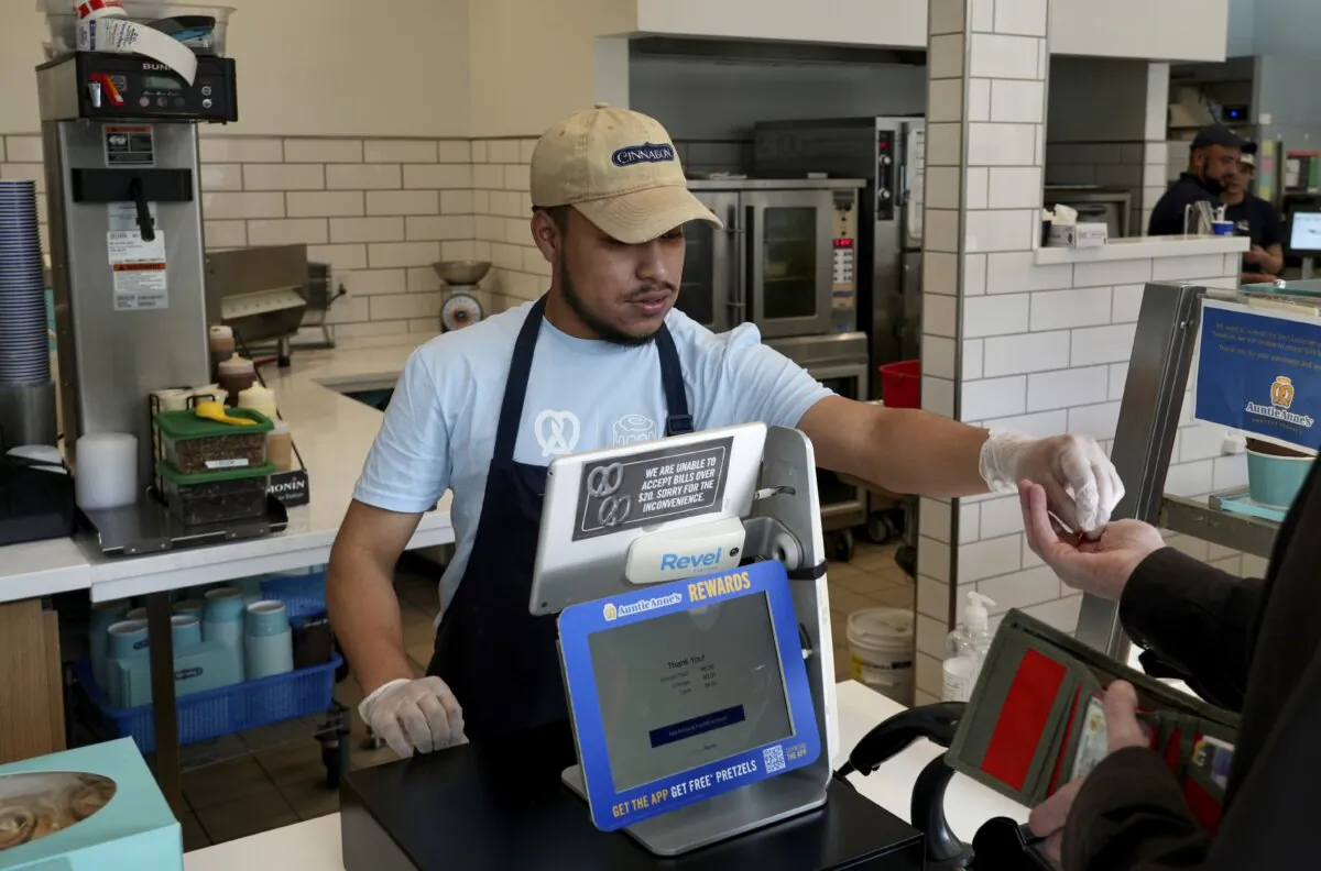 An employee collects payment at an Auntie Anne's and Cinnabon store in Livermore, Calif., on March 28, 2024. (Terry Chea/AP Photo)