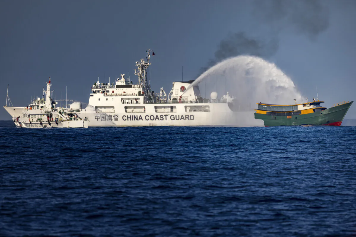 A China Coast Guard ship fires a water cannon at Unaizah May 4, a Philippine Navy chartered vessel conducting a routine resupply mission to troops stationed at Second Thomas Shoal, in the South China Sea on March 5, 2024. (Ezra Acayan/Getty Images)