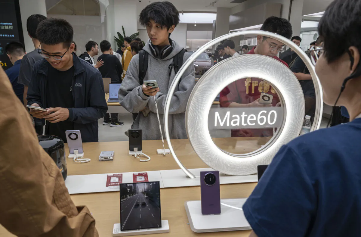People look at newly launched smartphones at a Huawei flagship store after the company unveiled new products, in Beijing on Sept. 25, 2023. (Kevin Frayer/Getty Images)