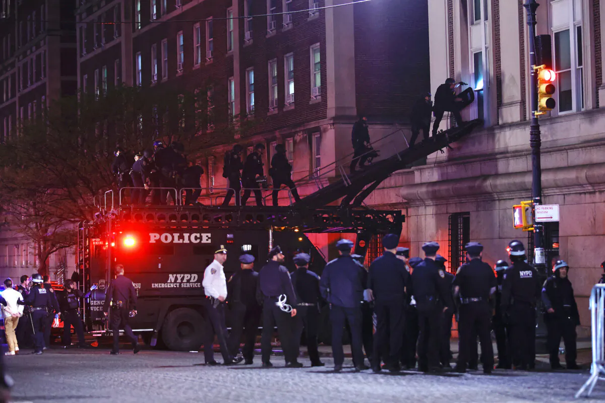 NYPD officers in riot gear break into a building at Columbia University, where pro-Palestinian students are barricaded inside a building and have set up an encampment, in New York City on April 30, 2024. (Kena Betancur/AFP)