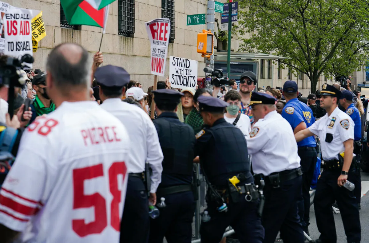 Police control barricades outside Columbia University after a protesting woman was arrested in New York on April 29, 2024. (Enrico Trigoso/The Epoch Times)