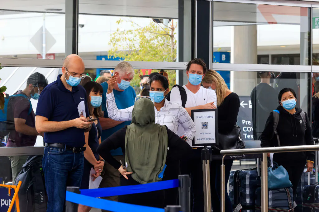 People line up at the Histopath pre-departure COVID testing clinic at Sydney International airport on December 23, 2021 in Sydney, Australia. Demand at COVID-19 testing centres across Sydney increased in the lead up to Christmas as NSW coronavirus case numbers rise. People travelling to Queensland, Tasmania and South Australia were required to show a negative PCR test to enter those states while Western Australia's borders are closed to NSW travellers. (Photo by Jenny Evans/Getty Images)