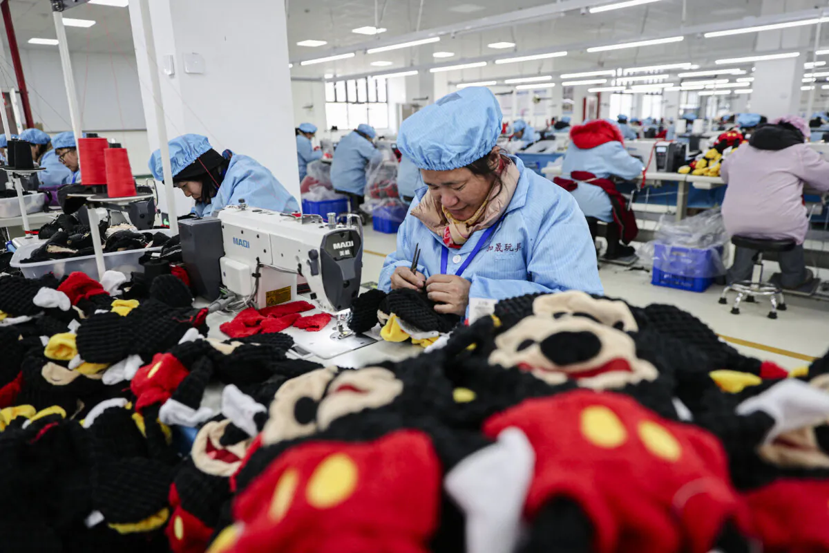 Employees work on a doll production line at a toy factory in Lianyungang, Jiangsu Province, China, on March 13, 2024. (STR/AFP via Getty Images)