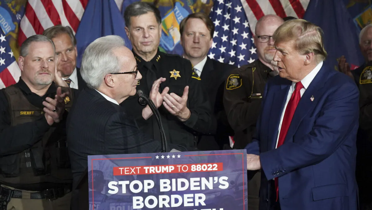 James Tignanelli (L), president of of the Police Officer Association of Michigan, greets former President Donald Trump and announces his group's endorsement of the former president during a speech at the Grand Rapids Convention Center in Grand Rapids, Mich., on April 2, 2024. (Gary Du for The Epoch Times)
