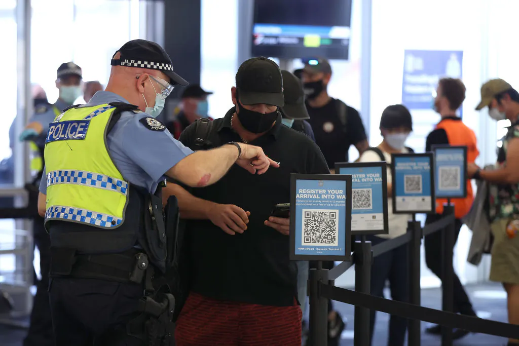 Arriving passengers scan the arrival registration QR codes at the Qantas Domestic terminal on February 05, 2022 in Perth, Australia.  (Photo by Paul Kane/Getty Images)