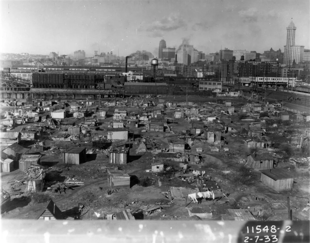 A "Hooverville" stood on the waterfront of Seattle during the Great Depression in 1933. Grim collections of shacks on vacant lots were cruelly called Hoovervilles after then-President Herbert Hoover. Hoovervilles are now on the verge of being replicated under President Joe Biden. (Seattle Municipal Archives, Public Domain)