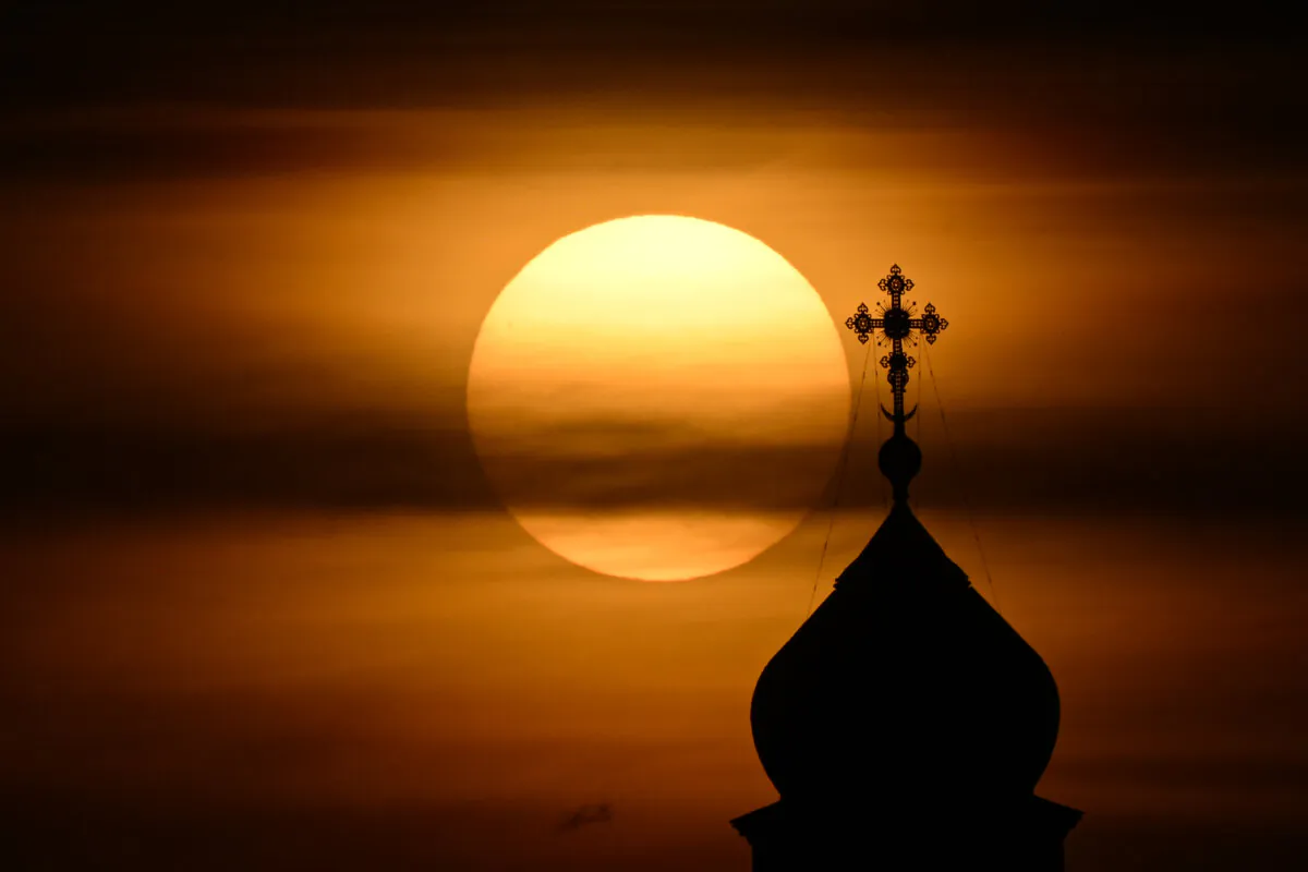 The sun sets behind a dome of the Christ the Saviour cathedral, the main Russian Orthodox church in downtown Moscow, on Oct. 25, 2022. (Natalia Kolesnikova/AFP via Getty Images)