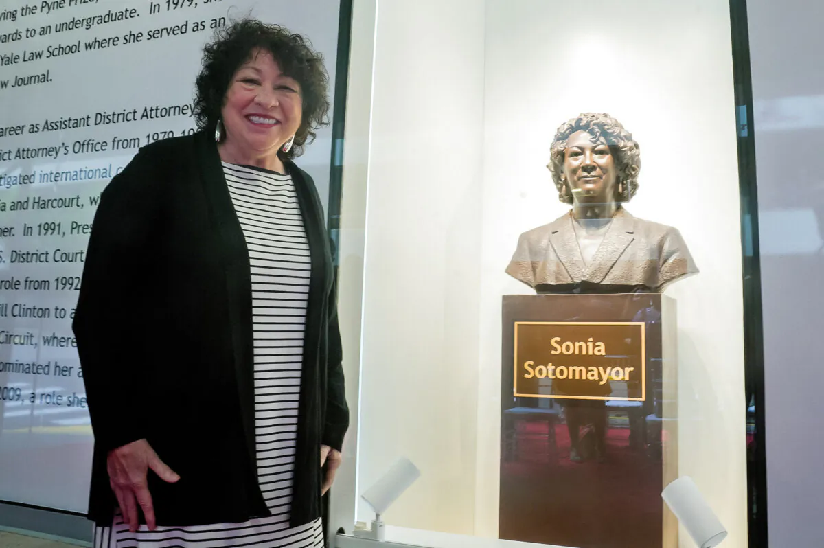 Supreme Court Justice Sonia Sotomayor poses for a photo next to a bronze bust of herself after it was unveiled at the Bronx Terminal Market in New York, on Sept. 8, 2022. (Bebeto Matthews/Pool via REUTERS)